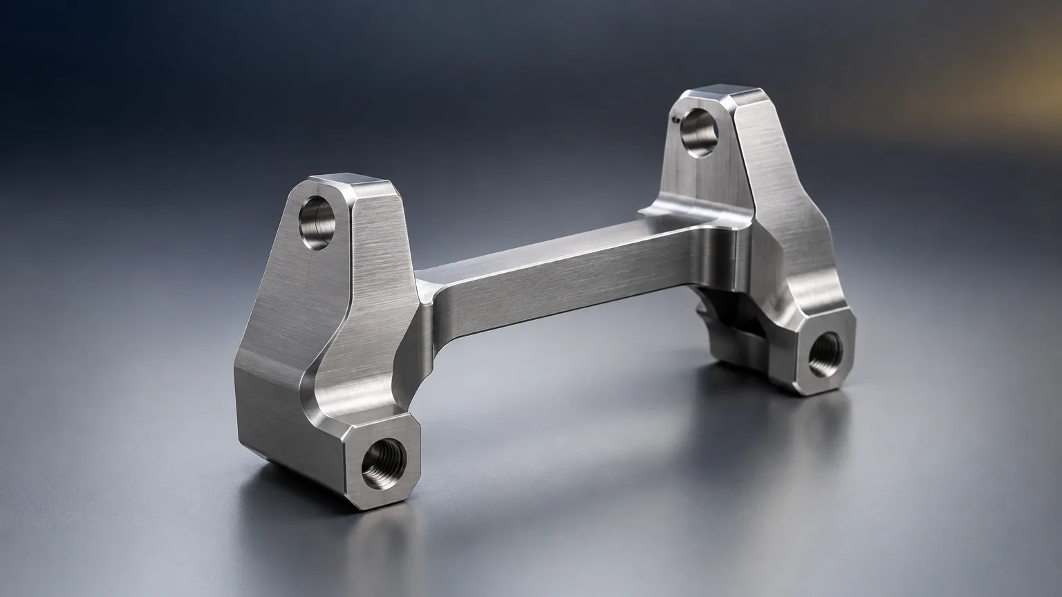 Precision-machined brushed steel brake bracket representing aftermarket auto parts manufacturing quality
