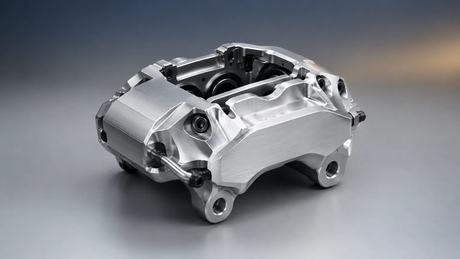 CNC machined aluminum automotive prototype bracket next to a production part